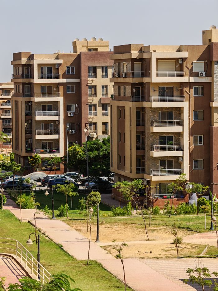 our-mission Contemporary residential apartments with green landscape in a sunny urban setting.