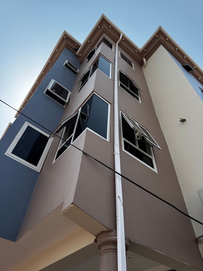 our-value Exterior view of a tall modern building with open windows in Accra, Ghana.