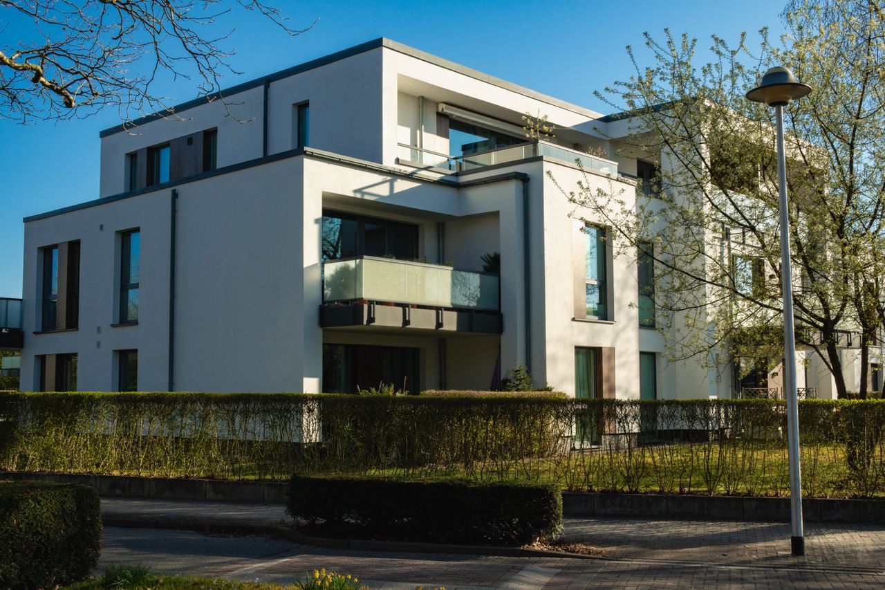 about-01 Contemporary luxury apartment building surrounded by spring greenery in a residential area.